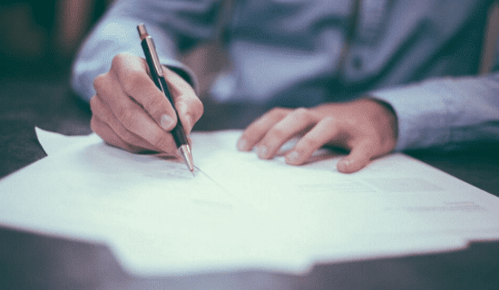 A man signing paperwork