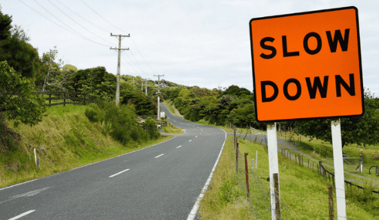 a road and a slow down sign 