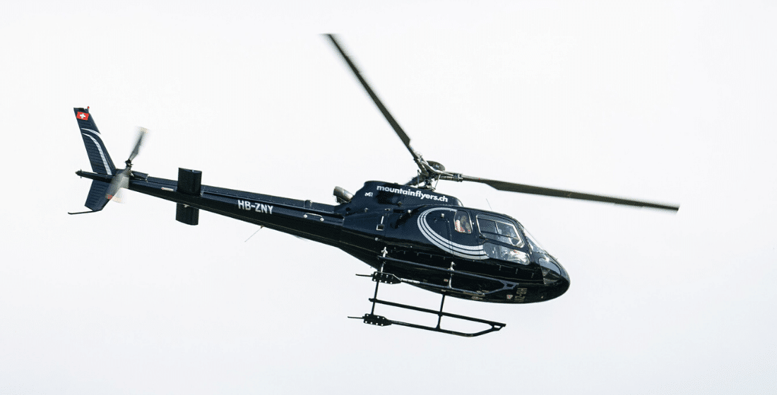 A black and white helicopter midflight